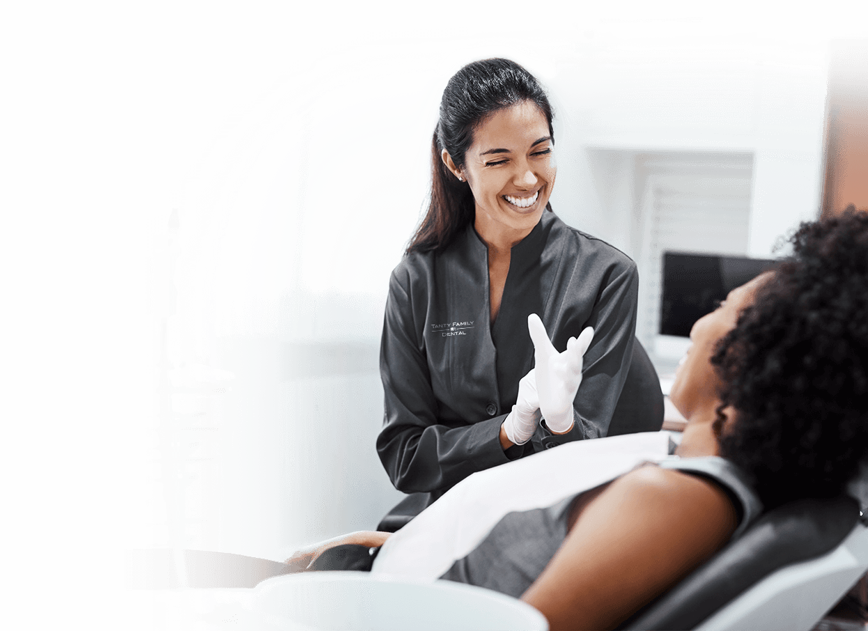 Smiling Dentist Talking with Dental Patient in Chair